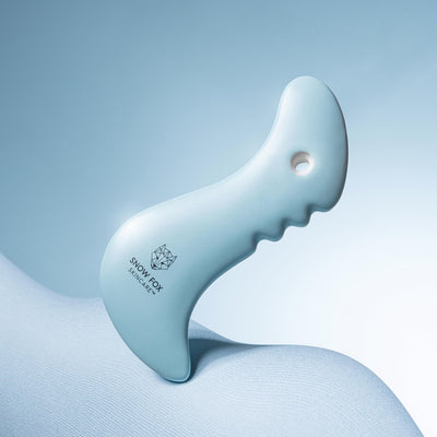 A fine porcelain, facial slimming Gua Sha specially designed by reflexologists to reach lymphatic drainage points under the chin to minimize bloating and sagging, naturally lifting and contouring the face especially around the jawline.