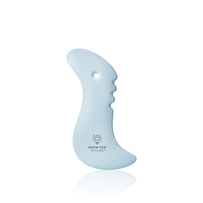 A fine porcelain, facial slimming Gua Sha specially designed by reflexologists to reach lymphatic drainage points under the chin to minimize bloating and sagging, naturally lifting and contouring the face especially around the jawline.